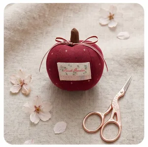 Close-up detail of the cute red fabric apple pendant charm with elegant bow and pretty label.