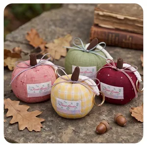 Detail view of cute fabric pumpkin plush keychains with bows and metal rings for autumn decor.