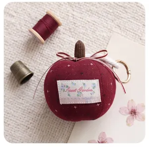 Cute plush apple car charm with ribbon bow and keychain, perfect rearview mirror decoration.