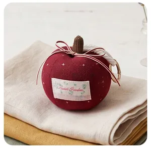 Cute red apple plush keychain detail, fabric bow design with metal ring accessory.