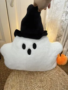 Dettaglio cuscino in peluche fantasma di Halloween con tessuto bianco e cappello da strega.