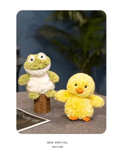 Close-up detail of cute yellow duck and green frog plush toys set on desktop. Soft fabric.