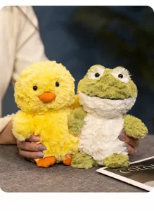 Close-up view of cute yellow duck and green frog plush toys, showing soft fluffy texture.