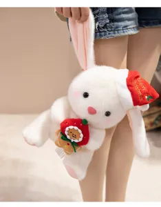 Vista detallada del lindo peluche de conejo de Navidad que sostiene un hombre de jengibre
