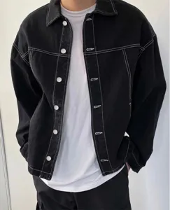 Lässige schwarze Herren Jeansjacke mit kontrastierenden weißen Nähten und Druckknöpfen.