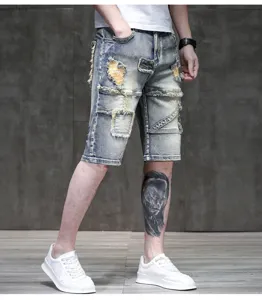 Distressed light wash denim shorts with patches and retro style for summer men.