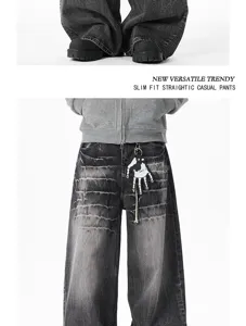 Detailed view of dark washed baggy jeans with vintage distressed finish and skeleton hand decor.