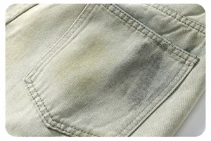 Detalle de jeans vaqueros con efecto sucio y desgastado, bolsillo trasero de estilo streetwear.