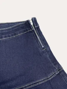 Dark blue denim skirt detail featuring side metal zipper and contrast stitching elements.