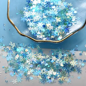 Close-up detail of mixed blue snowflake and heart glitter sequins for DIY crafts and decor.