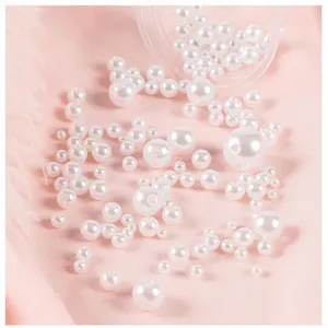Close-up detail of assorted white plastic imitation pearl beads for DIY crafts and jewelry.