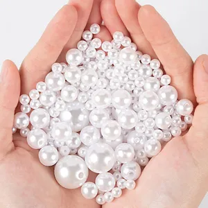 Mixed size white plastic imitation pearl beads with holes for DIY jewelry making and crafts.
