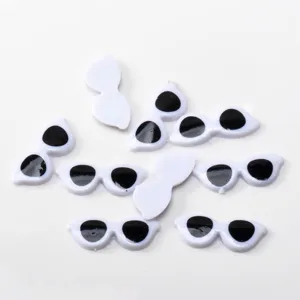 Vista detallada de cabujones de ojos de muñeca blancos y negros, ideales para manualidades DIY.