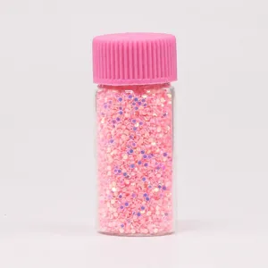 Πολύχρωμα πούλιες γκλίτερ για nail art και χειροτεχνίες με εποξειδική ρητίνη σε ροζ μπουκάλι.