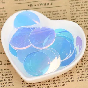 Detailed view of transparent iridescent DIY sequin charms, side-hole round craft pieces.