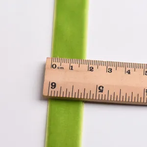 Green velvet ribbon for DIY crafts, bows, and holiday decorations, smooth fabric texture.