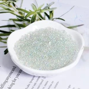 Close-up of transparent iridescent bubble beads in a white dish, craft DIY decoration.