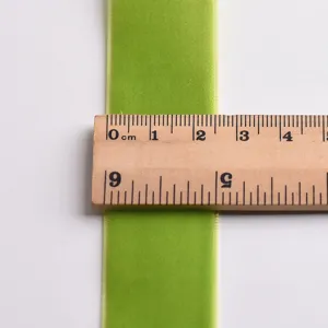 Green velvet ribbon detail view, soft plush texture webbing for DIY crafts and bows.