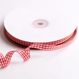 Vista detallada de cinta a cuadros rojo y blanco, ideal para manualidades y decoración.