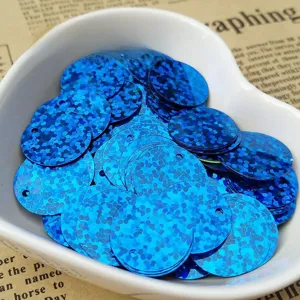 Close-up detail of blue holographic round sequins with hole for DIY crafts and clothing decor.