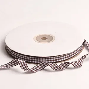 Primer plano de un rollo de cinta a cuadros marrón y blanco de 10mm para manualidades DIY.