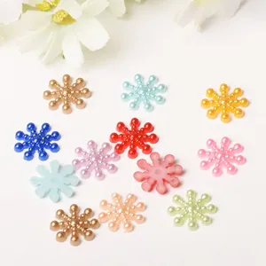 Snowflake pearl appliques close-up detail, colorful DIY phone case craft materials.