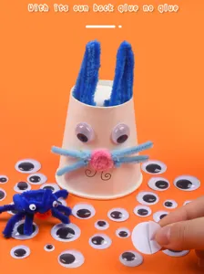 Detailed view of black and white googly eyes with self-adhesive backing for fun DIY crafts.