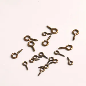 Detail shot of bronze screw eyes, metal eyelets and mini hooks for DIY handmade jewelry crafts.