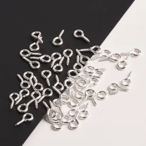 Detail shot of silver metal eye pins, small screw hooks for DIY jewelry making and craft projects.