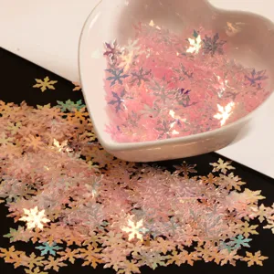 Gros plan de paillettes de flocon de neige roses iridescentes pour nail art et bricolage.