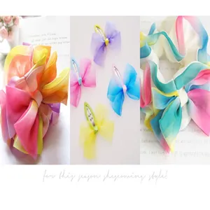 Gradient organza hair bows and scrunchies detail view showing vibrant colors and fabric texture.