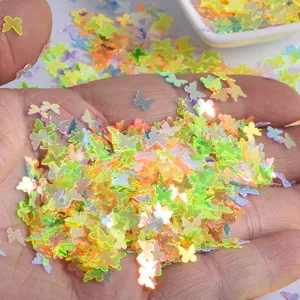 Close-up detail shot of colorful iridescent butterfly nail art glitter sequins for DIY crafts.