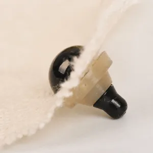 Close up detail shot of black plastic safety eyes for DIY plush doll making and crafts.