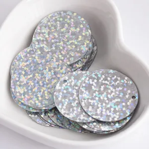 Close-up detail of 25mm holographic round sequins with side holes for DIY crafts and apparel.