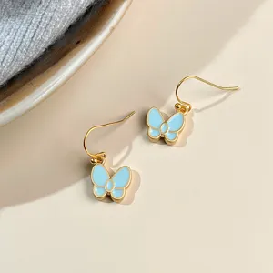Sweet light blue enamel butterfly drop earrings, delicate gold-tone metal fishhook design for women.