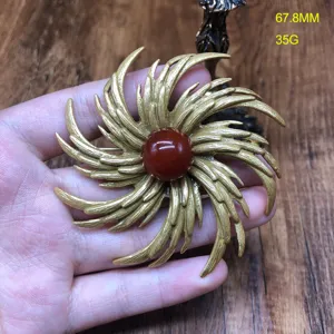 Vintage sunburst brooch with red agate stone, elegant gold plated jewelry piece for women.