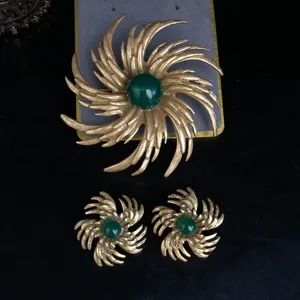 Vintage retro gold-plated sunburst brooch and earrings set with dark green stone details.