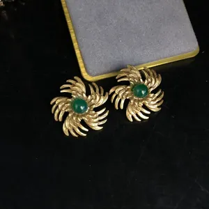 Vintage gold-plated green agate earrings featuring an intricate swirl textured metal design.