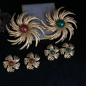 Vintage gold-plated brooch and earrings set with red and green stones, elegant retro jewelry.