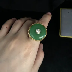 Vintage green ping an kou ring detail showcasing gold beaded rim and sparkling rhinestone center.