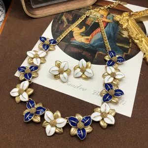 Set collana e orecchini con fiori in smalto blu e bianco in stile vintage con finitura dorata.
