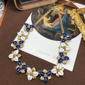 Primo piano della collana con fiori smaltati vintage e raffinato design blu e bianco.