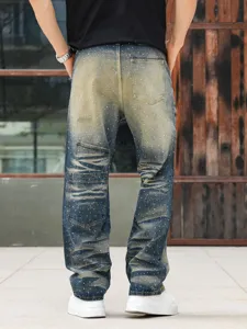 Detailed view of men's loose straight-fit distressed denim jeans with rhinestone accents.