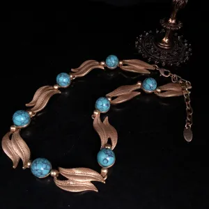 Vintage turquoise leaf necklace detail, antique gold metal alloy fashion jewelry accessory.