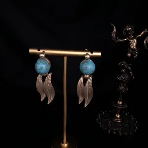 Vintage retro style turquoise bead and metal leaf dangle earrings elegant detail view.