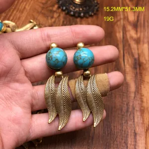 Detailed view of vintage turquoise earrings with gold leaf pendants, showcasing fine craftsmanship.