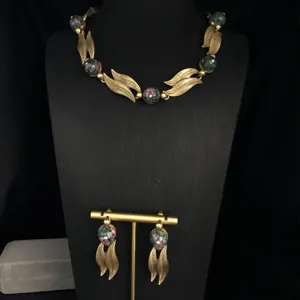Vintage gold leaf necklace and earrings set with gemstone beads, elegant detail showcase.