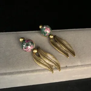 Vintage style double feather dangle earrings with patterned stone beads for women jewelry detail
