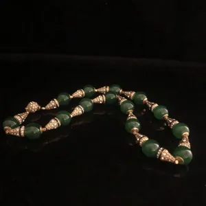 Detail view of vintage green agate beaded necklace with crystal paved cone spacers, retro style.