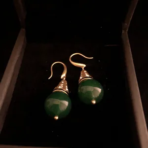 Vintage green agate gemstone drop earrings with rhinestone details in black jewelry box detail.